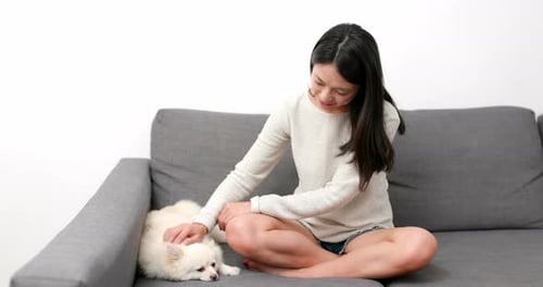 Woman Posing with Her Pet Pomeranian on Couch