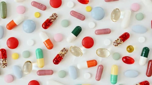 Bunte medizinische Pillen rotierende Nahaufnahme auf weißem Hintergrund