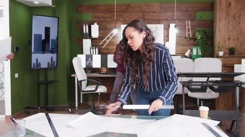 Young Architect Arriving at the Office with Blueprints