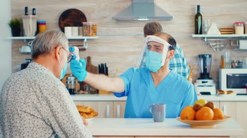 Caregiver Measuring Senior Temperature