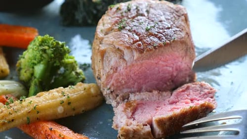 Close Up of Man Hand Cut Slice of Fresh Grilled Steak in Luxury Restaurant