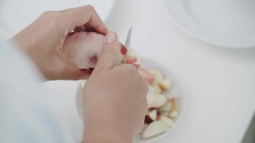 Person Peeling an Apple with a Paring Knife