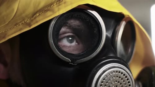 Rack fokussierte Augen eines Überlebenden mit Gasmaske und gelbem Regenschutzanzug