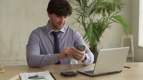 Man Using Smartphone While Sitting on Office and Using Phone