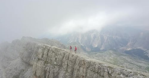 Aerial drone view of a man and woman couple hiking in the mountains