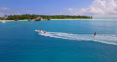 Aerial drone view of a man water skiing near a tropical island.