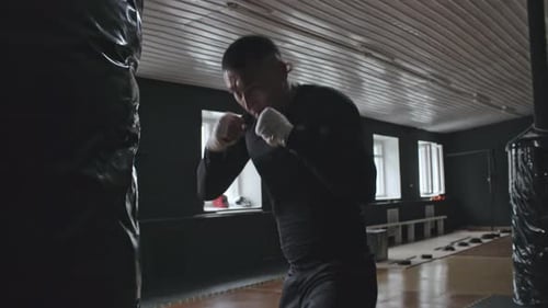 Man Boxing With Punching Bag at Gym