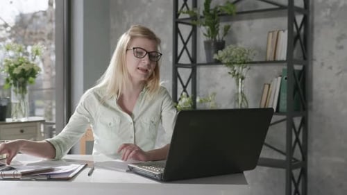 Woman Video Conferencing in Home Office with Laptop