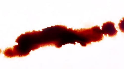 Ink Spreading Across White Surface Creates Abstract Effect