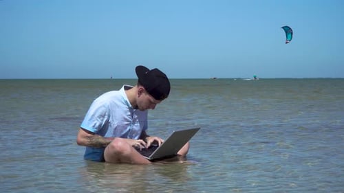 A Man Works on Vacation. The Guy in the Sea with a Laptop.