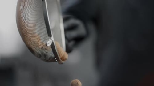 Dough Balls Sifted Through a Metal Strainer