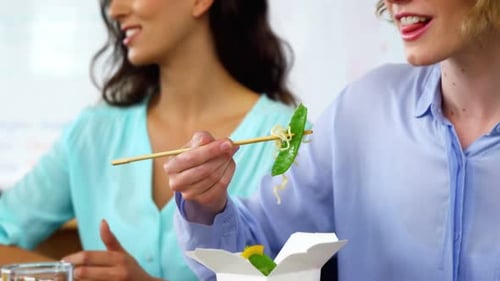 Colleagues Enjoying Noodle Takeout Lunch at Work