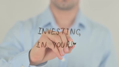 Hand Writes 'Investing In Yourself' on Glass