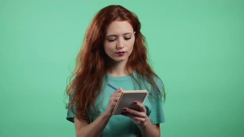 Woman Writes in Notebook on Green Screen