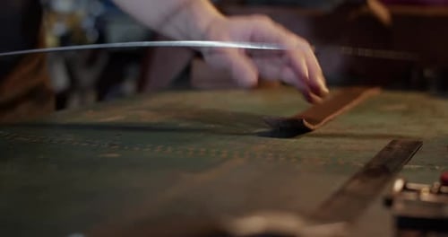 Leather Worker Cuts Piece of Leather with Knife