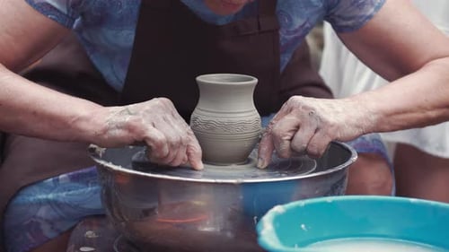 Grand-mère et petits-enfants fabriquent des pichets en poterie
