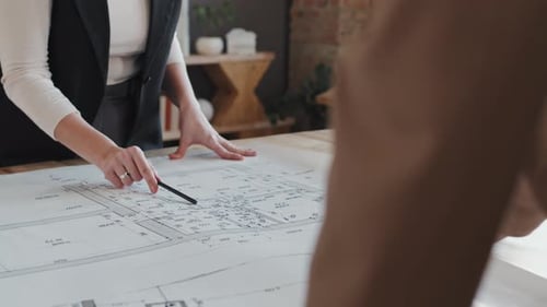 Architects Reviewing Blueprints in Modern Office