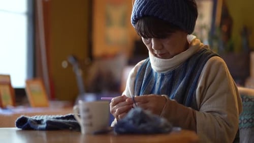 A woman knitting a neck warmer