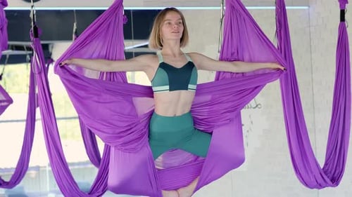 Young Woman Doing Aerial Yoga in Hammock