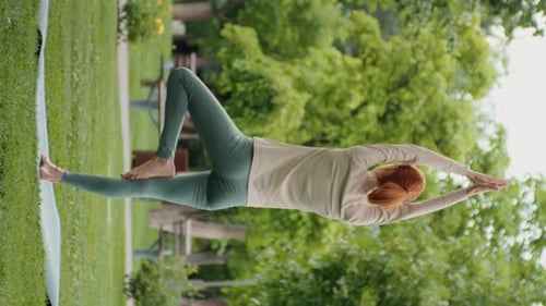 Vertical Screen Woman sitting in yoga pose and meditates in the park.