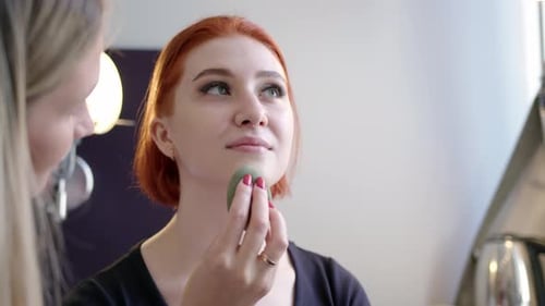 Woman Applies Makeup With Sponge