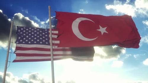 American and Turkish Flags Waving with Sun in Blue Sky