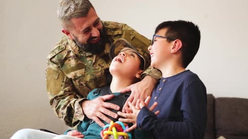 Soldier Hugging and Kissing Two Smiling Boys
