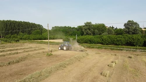 Tractor Machine Working on Hay Bales in Agriculture Wheat Field