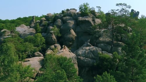 Woman Doing Yoga on Top of Rock Formation