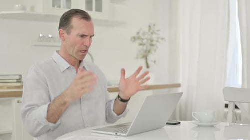 Frustrated Man Working on Laptop at Home
