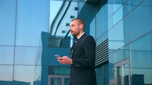 Young Businessman Using Smartphone Near Office and Celebrating Achievement. Business Man Found Out