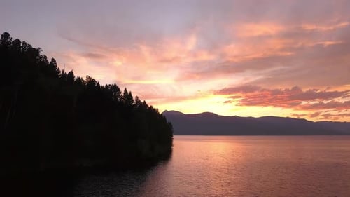Flying over lake during colorful sunset filling the landscape