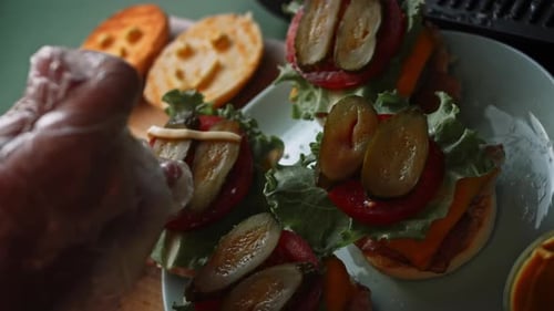 Burgers Being Prepared With Lettuce And Sauce