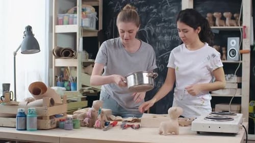 Young Adults Crafting Paper Mache Sculptures in Studio