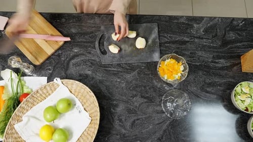 Woman cuts fruit at kitchen counter
