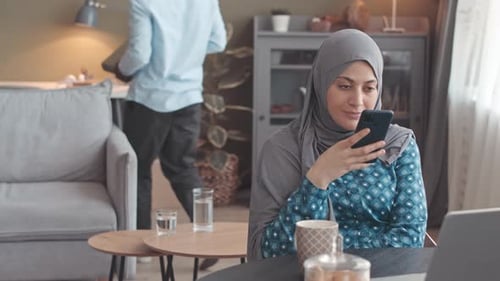 Femme musulmane travaillant à domicile avec sa famille