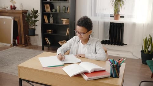Young Child Writing at Desk Doing Homework
