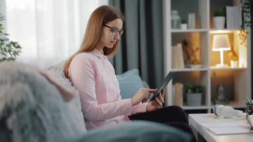 Woman Using Tablet Device on Couch