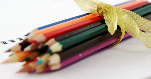 Colored pencils kept on the spiral book