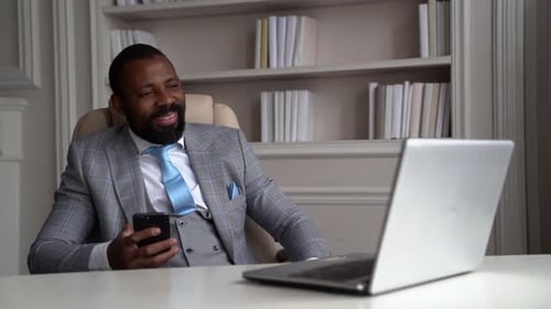 Cheerful Black Man Is Resting in Office at Break Time, Listening To Favorite Music and Dancing