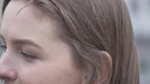 Extreme Close-up of Male Caucasian Hand Adjusting Hair of Young Brunette Woman with Brown Eyes