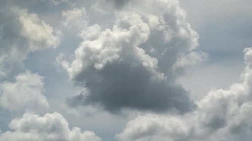 Fluffy White Clouds Drifting Across Blue Sky