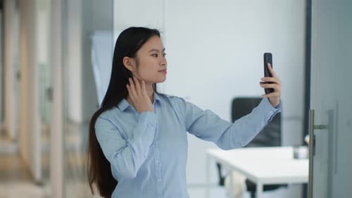Young Positive Asian Lady Making Selfie on Smartphone Posing and Smiling to Device Sending Blow Kiss