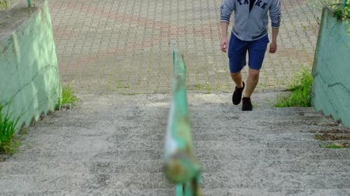 Young Man Walks Down Concrete Stairs