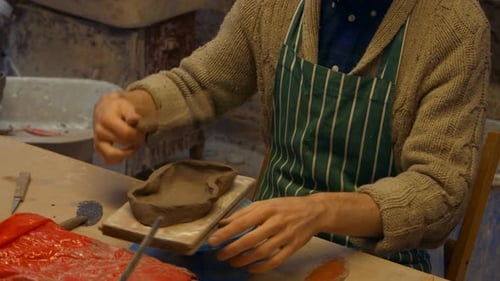 Potter Shaping Clay in Artistic Workshop