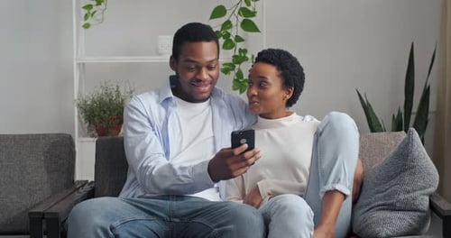 Young Couple Relaxing Together at Home with Phone