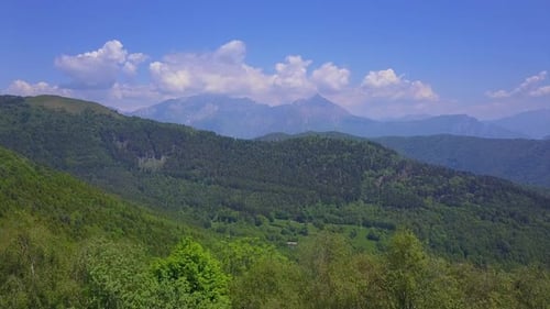 Drone Flying Over Green Trees Overlooking Mountain Peaks and Hills Covered with Forest, Highland