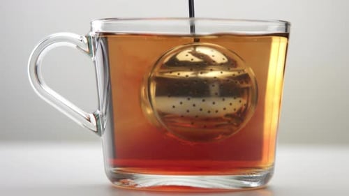 Transparent Cup with Tea in White Studio Space. Minimalistic Video Brewing Tea