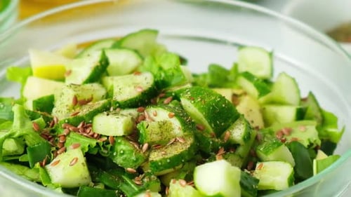Woman Cooking Salad of Fresh Green Vegetables and Herbs