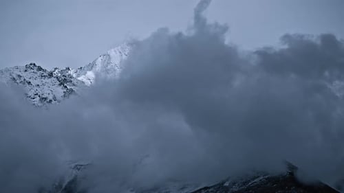 Wolken bewegen sich vor dem Berggipfel